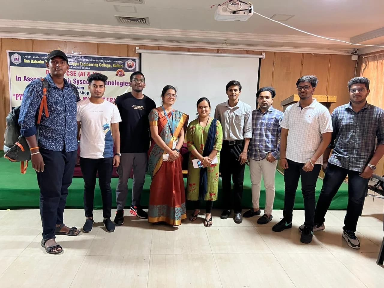 Group photograph on stage beneath the workshop banner for Python Programming and Machine Learning