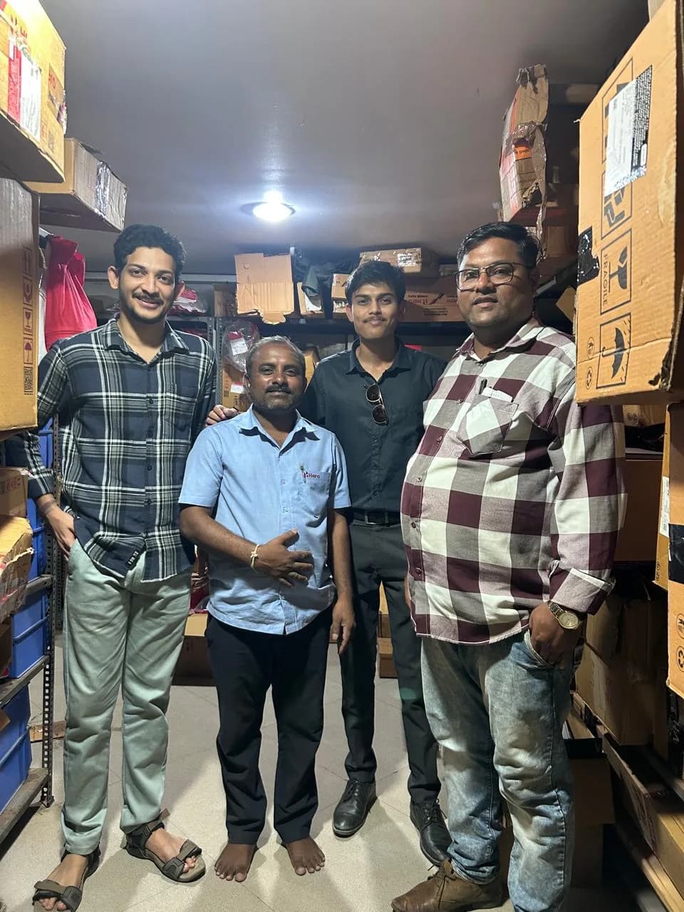 Standing with a dealership staff member among shelves of boxed spare parts