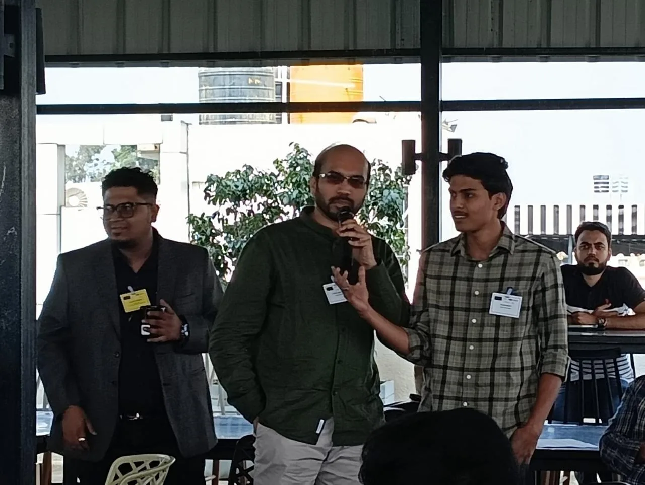 Addressing an audience with a microphone alongside other panellists