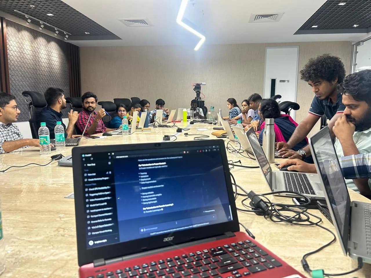 Participants working on laptops around a boardroom table during a practical session