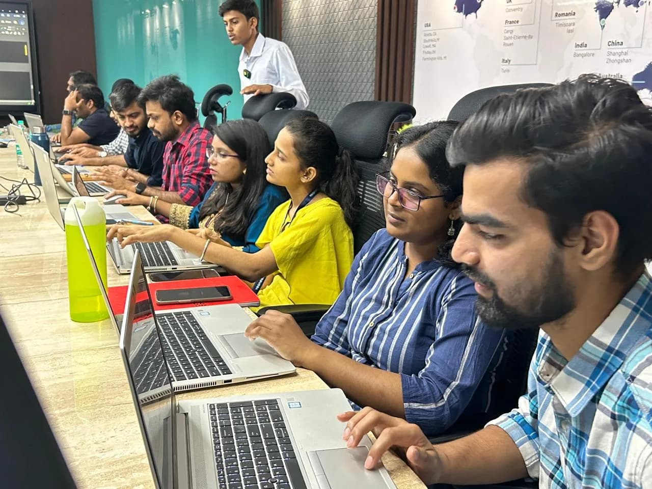 A row of participants typing on laptops during a training session